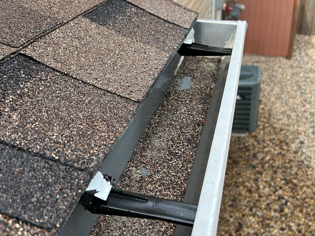 Granules collecting in a gutter — a sign your shingles are drying out